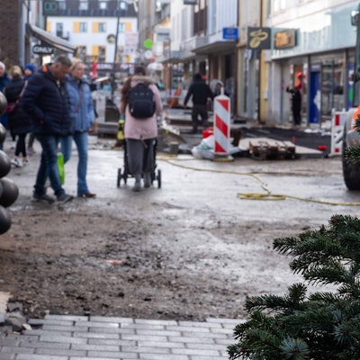 Das Bild zeigt die Euskirchener Fußgängerzone. Am rechten Bildrand ist ein Weihnachtsbaum zu sehen, im Hintergrund die Baustelle an der Neustraße.