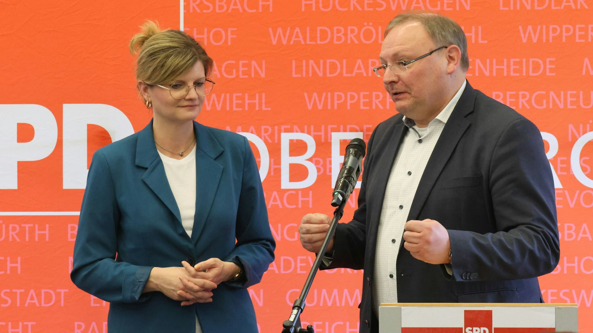 Eine Frau und ein Mann stehen zusammen am Rednerpult.