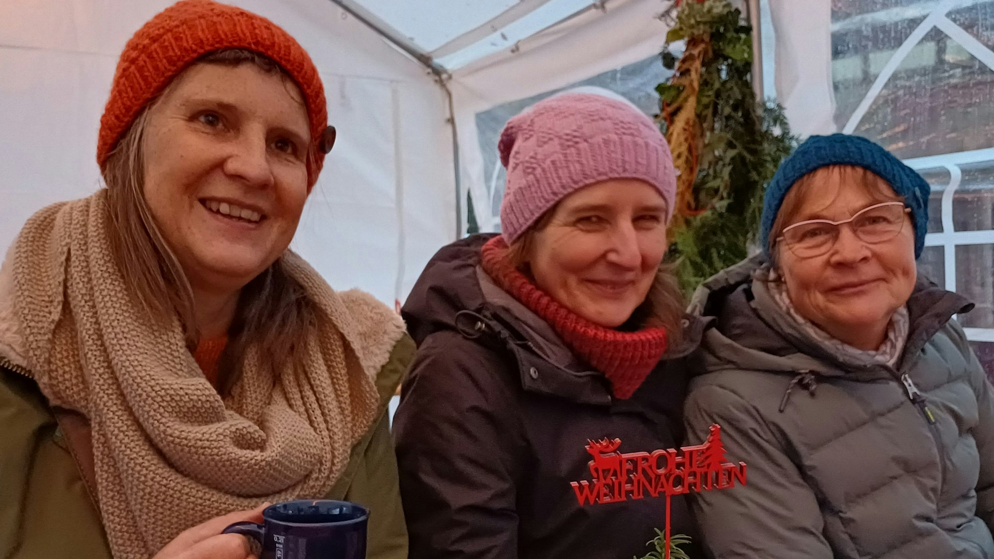 Drei Frauen mit Mützen und Glühwein