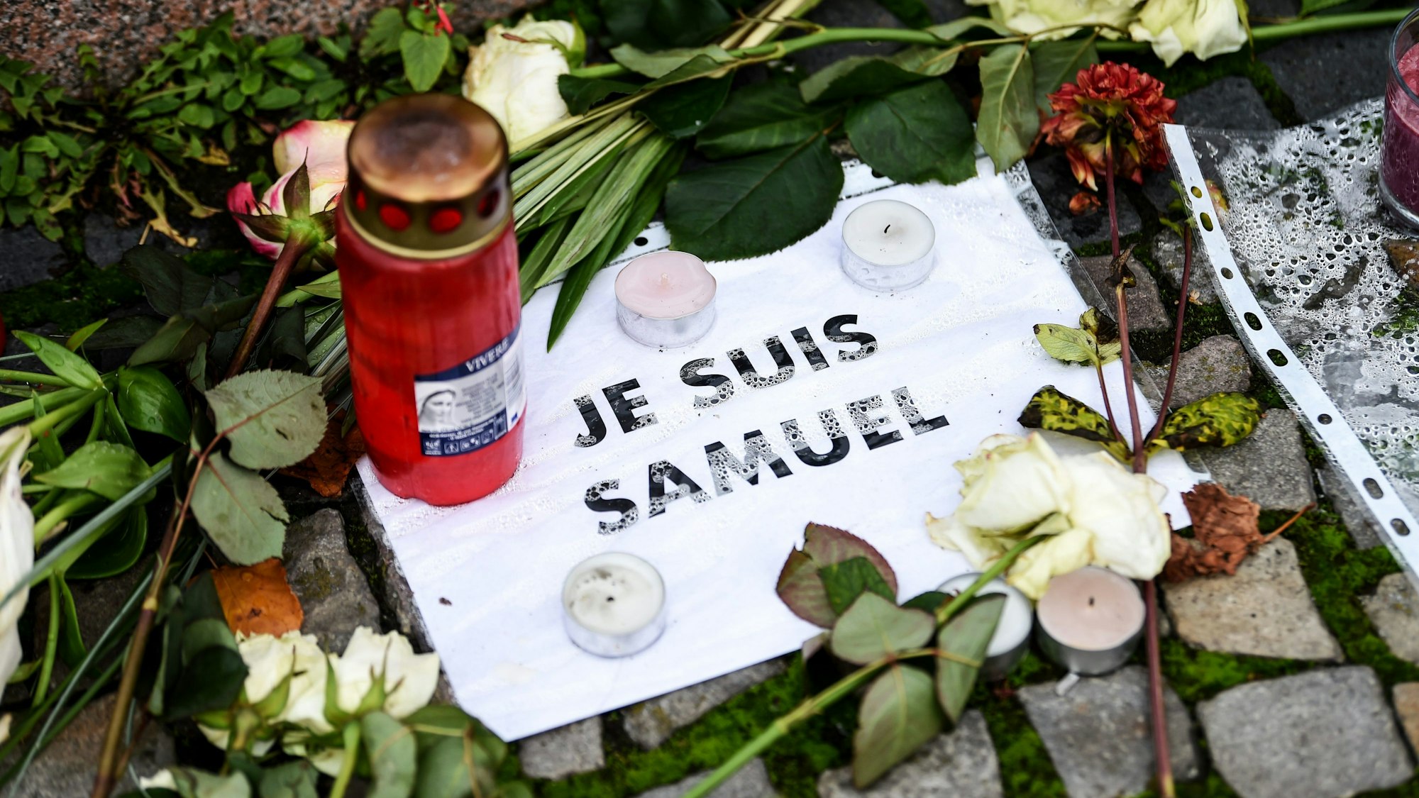 Vor der französischen Botschaft liegen Blumen, Kerzen und ein Blatt mit der Aufschrift „Je suis Samuel“. (Symbolbild)