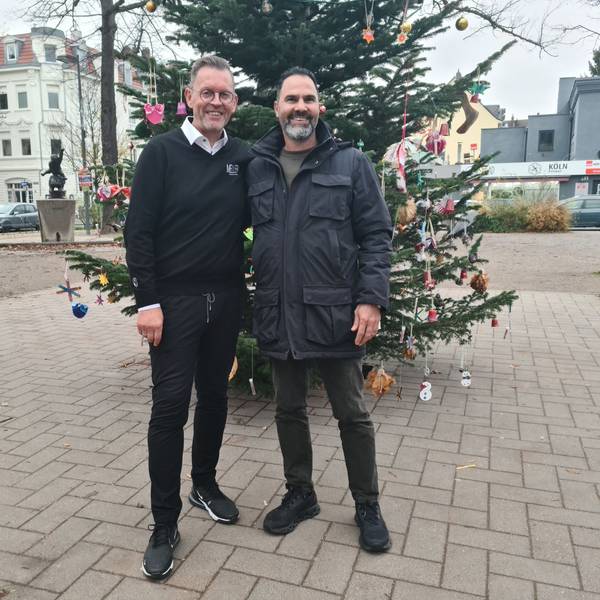 Zwei Leute vor einem Weihnachtsbaum.