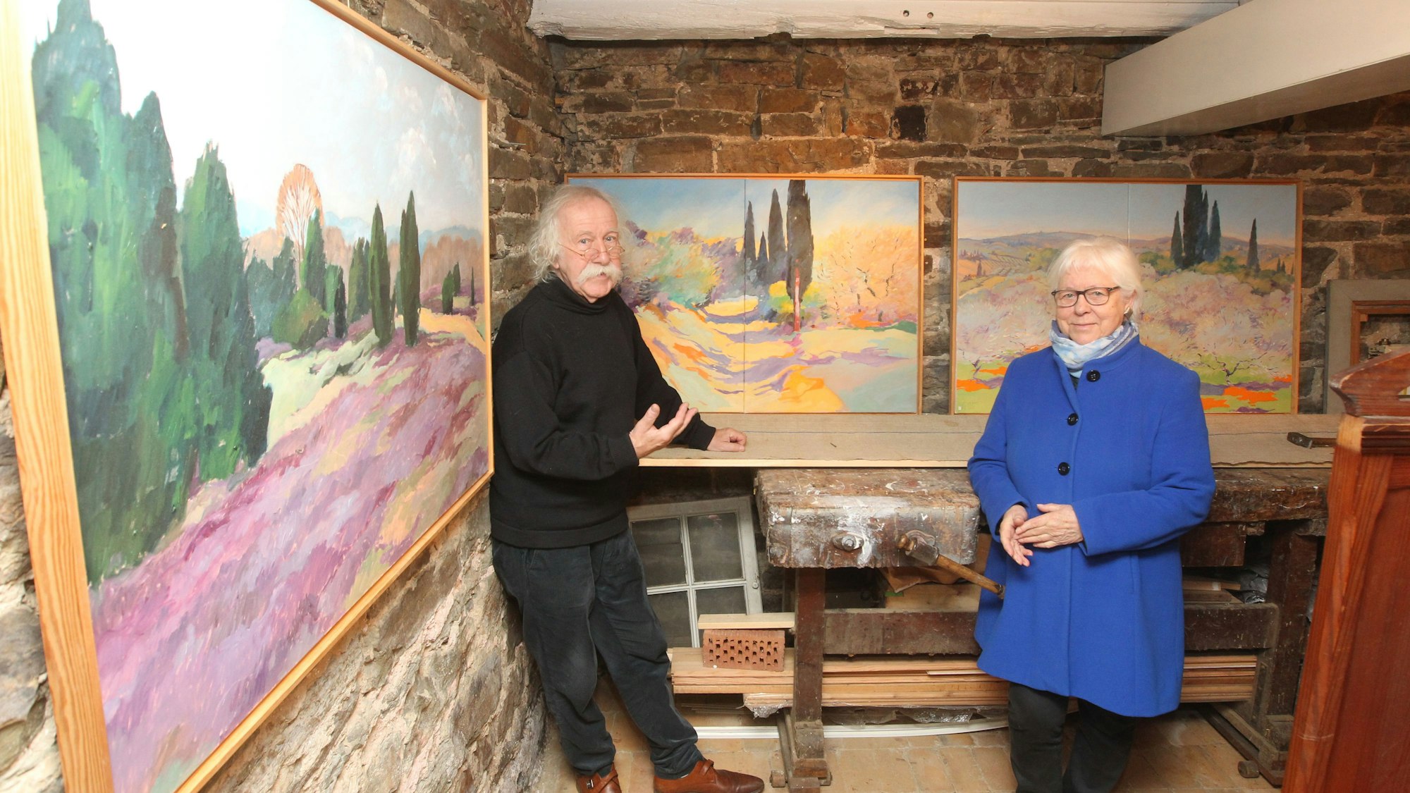 Die Witwe Brigitte Päkel und Burhard Sondermeier vor den Bildern des verstorbenen Malers Klaus Päkel.