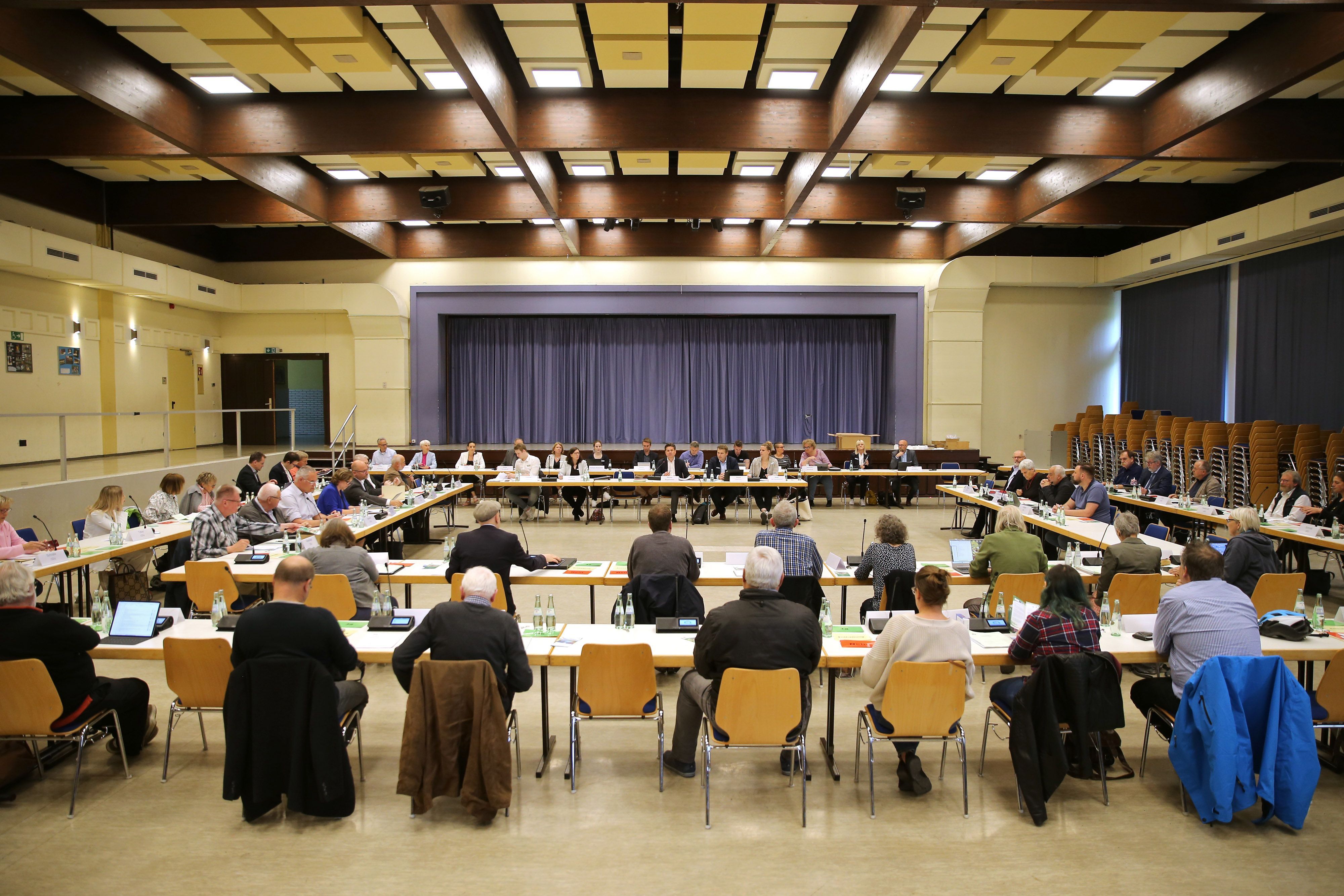 Politiker sitzen in großer Runde in der Aula des Bielsteiner Schulzentrums.