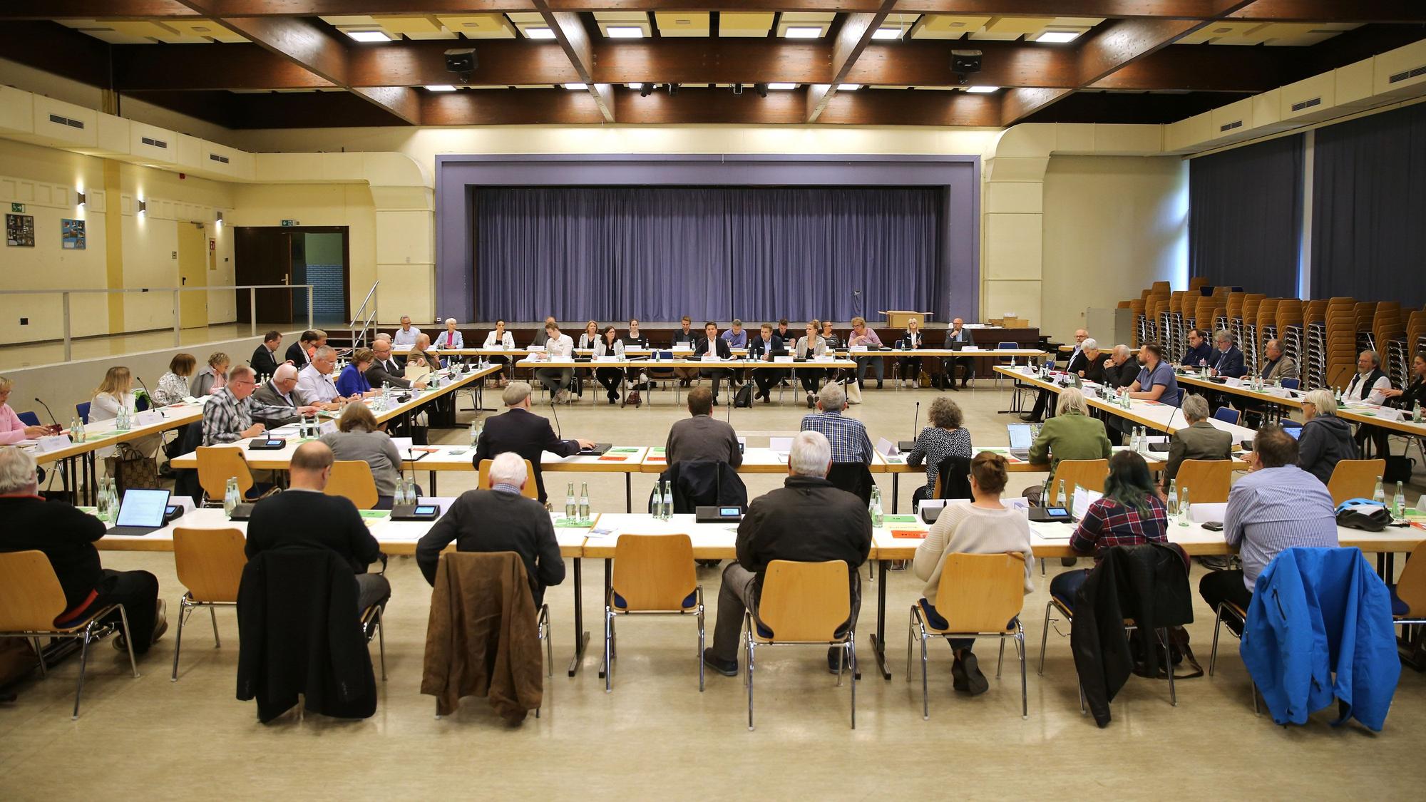 Politiker sitzen in großer Runde in der Aula des Bielsteiner Schulzentrums.