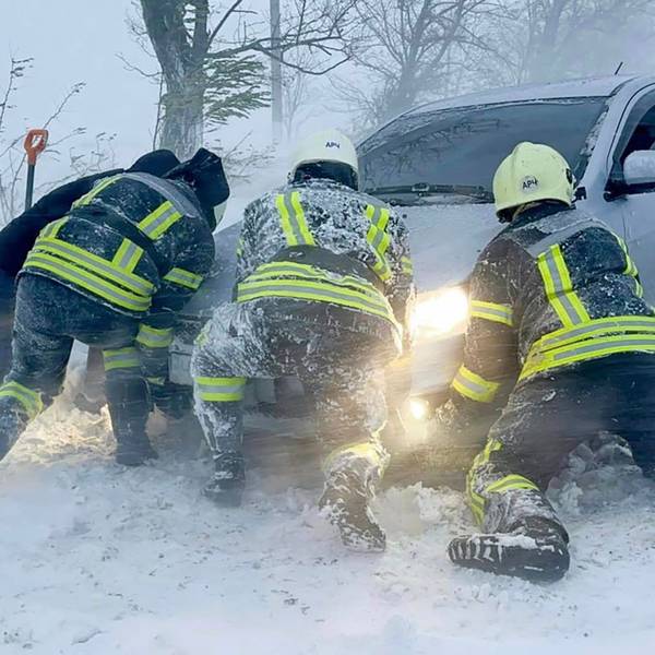 Auf diesem vom ukrainischen Rettungsdienst zur Verfügung gestellten Bild versuchen ukrainische Rettungskräfte ein im Schnee steckengebliebenes Auto auf der Autobahn in der Region Odessa zu schieben.
