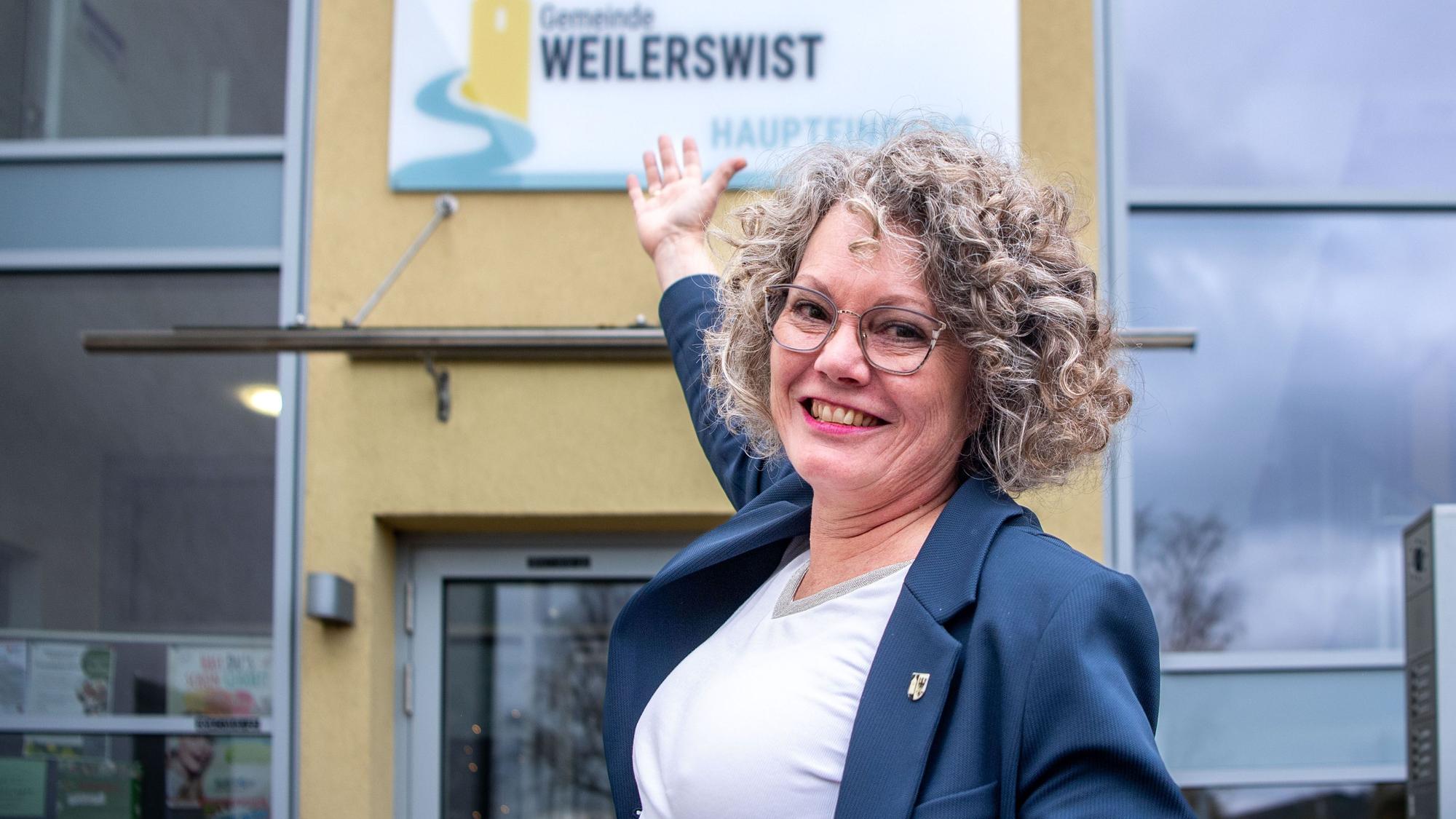 Bürgermeisterin Anne Horst zeigt auf das neue Schild am Rathaus.