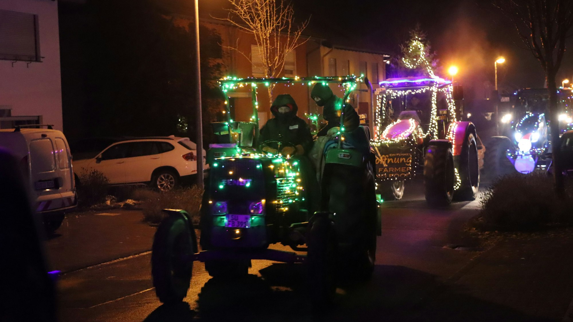 Auf dem Foto ist ein Traktor-Korso bei Dunkelheit zu sehen.