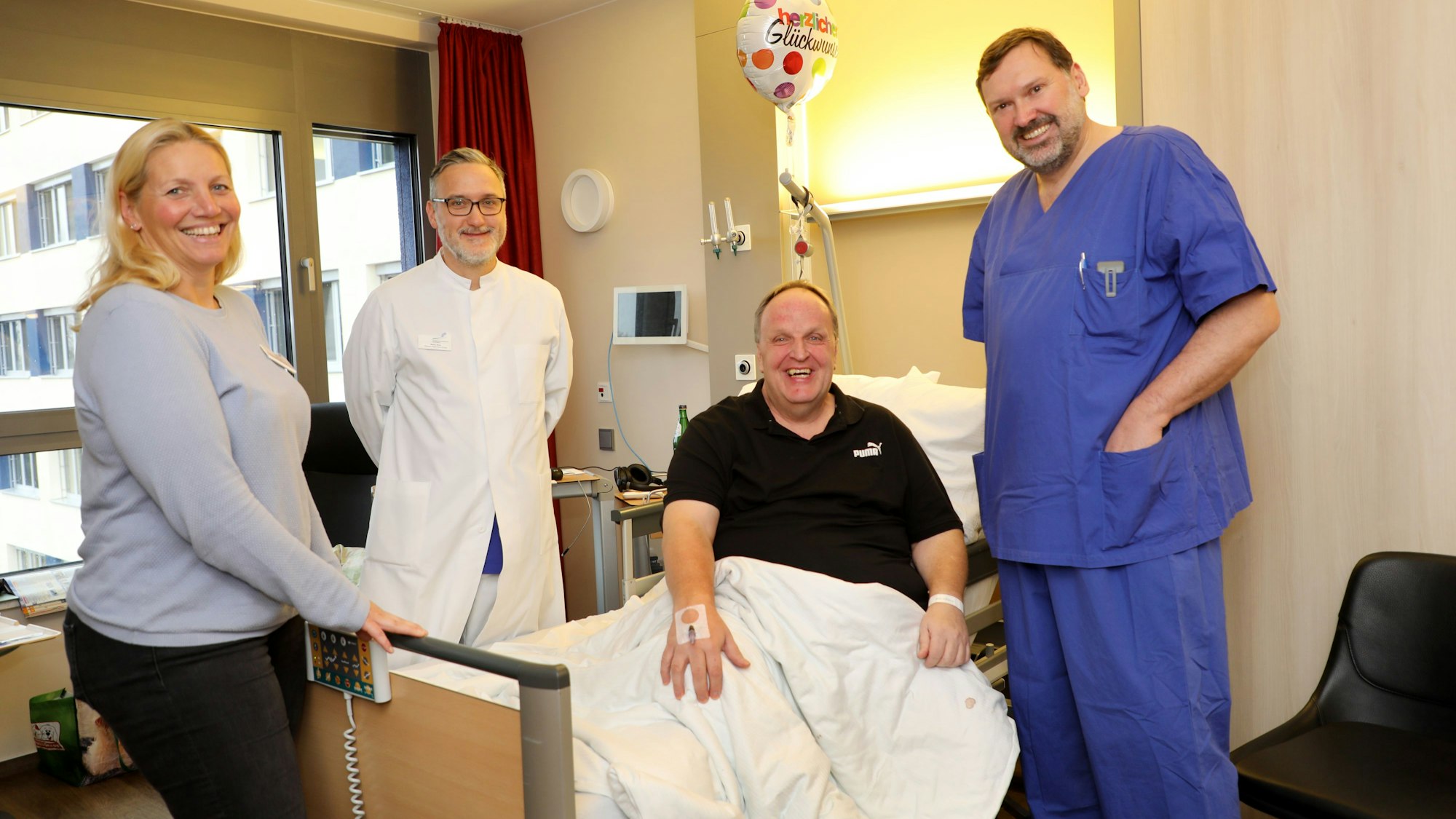 Am Krankenbett von „Flöckchen“-Sänger Uwe Kraus stehen (v.l.) Patientenkoordinatorin Verena von Mengden, Oberarzt Marko Skok und Chefarzt Dr. Andreas Hecker.