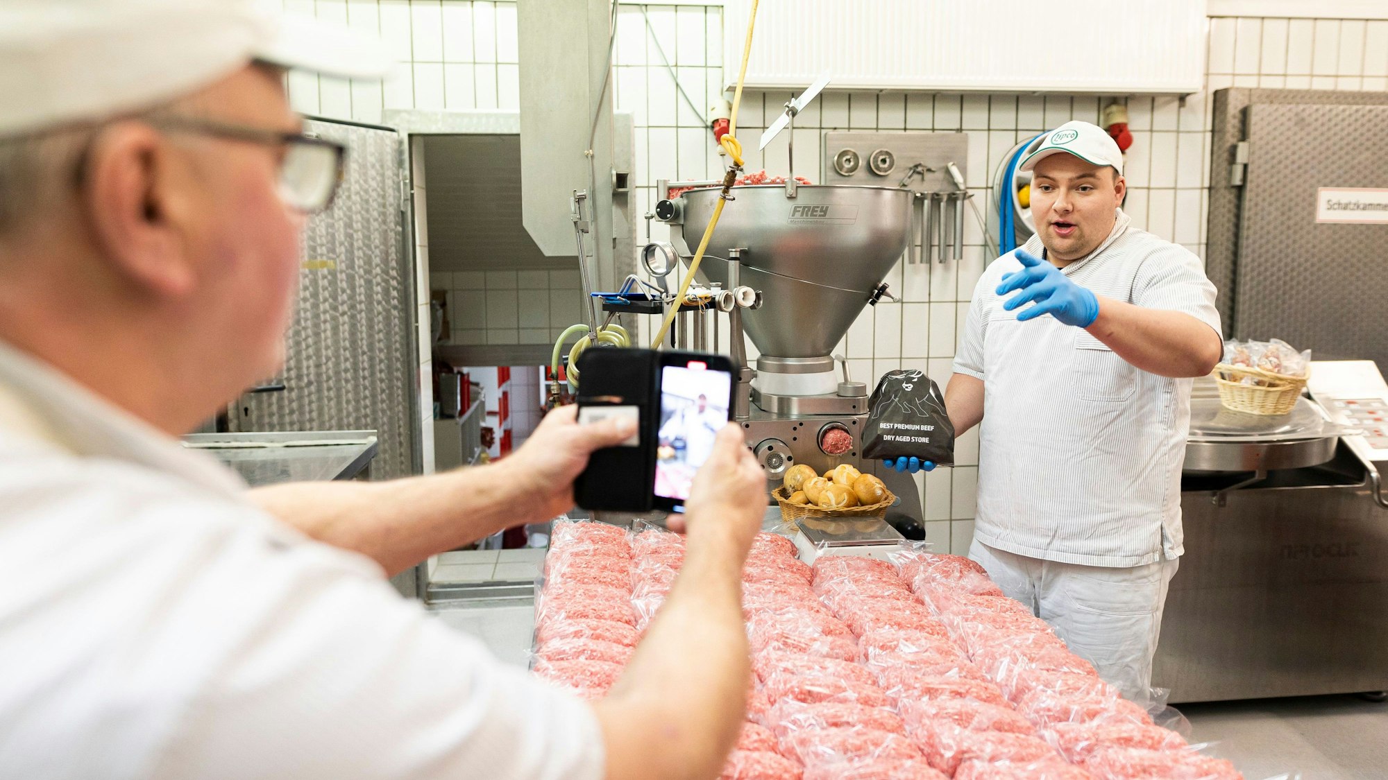 Alexander Richter (r), Metzger, dreht zusammen mit seinem Vater Christoph Richter (l) in den Räumlichkeiten der Metzgerei „Spezi-Metzger“ seiner Familie ein Video für verschiedene Social Media Plattformen. Auf dem Tisch vor Alexander Richter liegen vorbereitete Mett-Ballen.