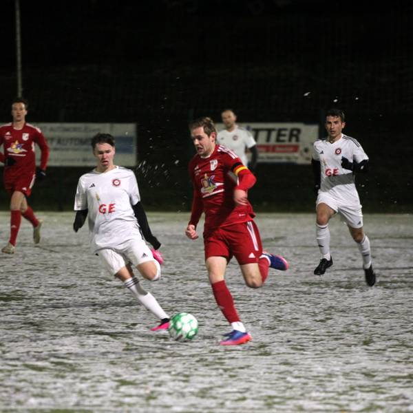 Ein Dahlemer Fußballer ist auf dem Schnee schneller als sein Frauenberger Gegenspieler.