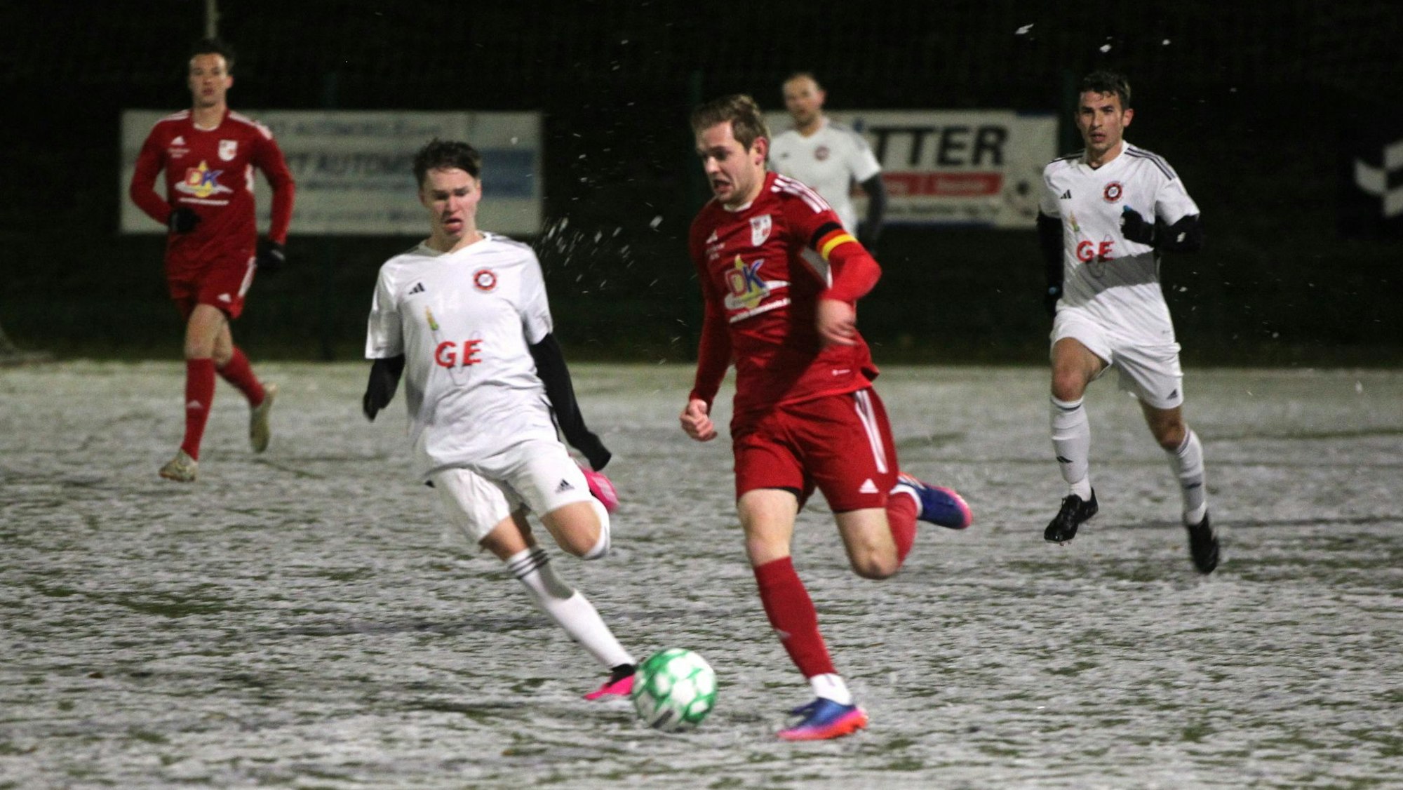 Ein Dahlemer Fußballer ist auf dem Schnee schneller als sein Frauenberger Gegenspieler.
