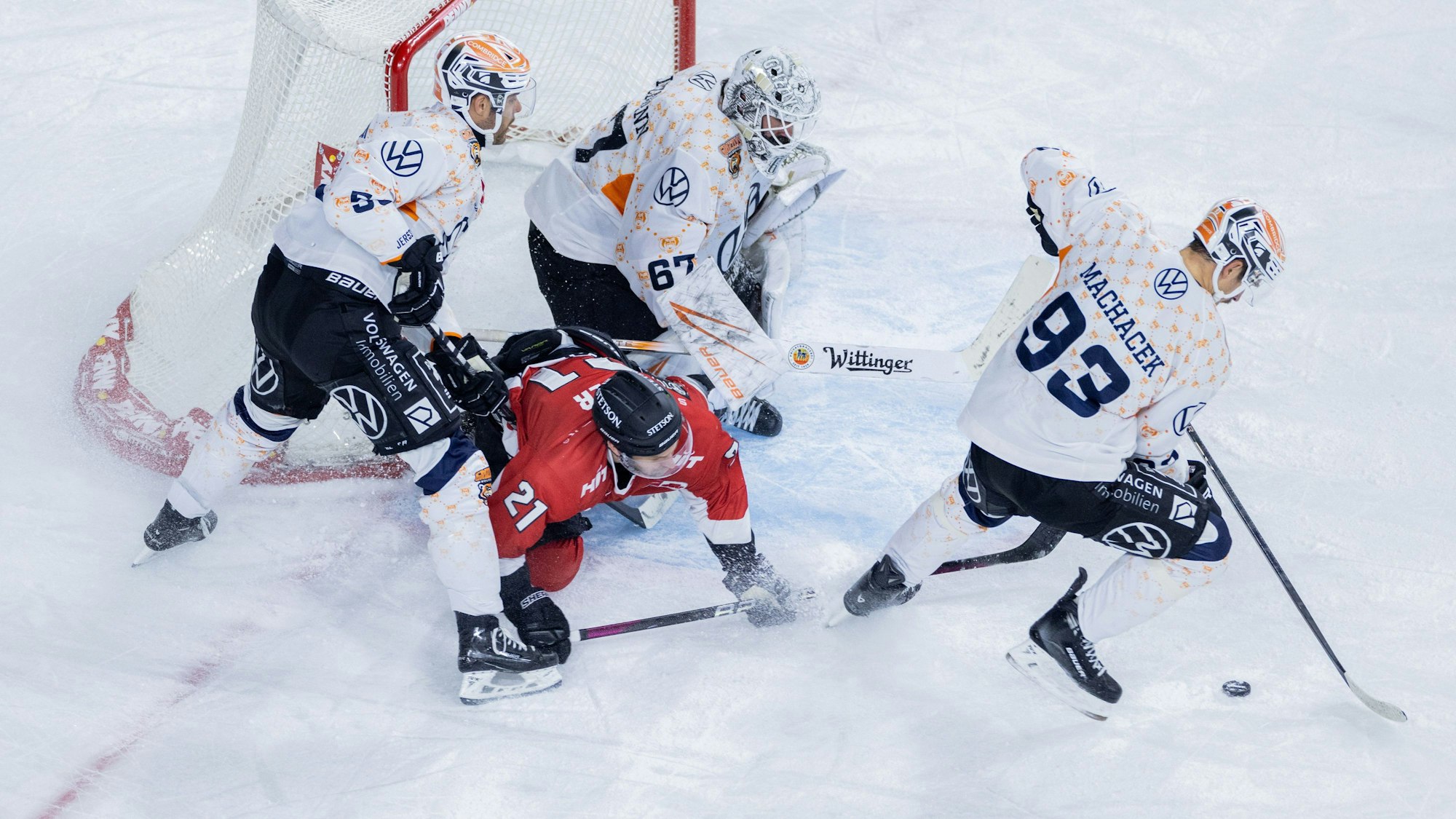 Kölns Mark Olver (unten) und Wolfsburgs Ryan Button (l-r), Hannibal Weitzmann und Spencer Machacek versuchen an den Puck zu kommen.