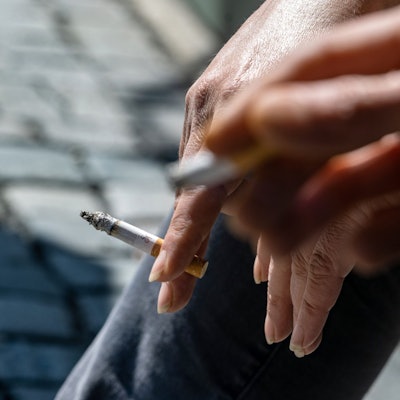 Raucher halten brennende Zigaretten in der Hand.