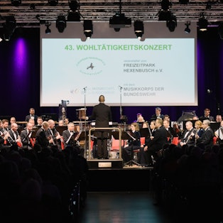 Ein Orchester spielt auf einer Bühne.