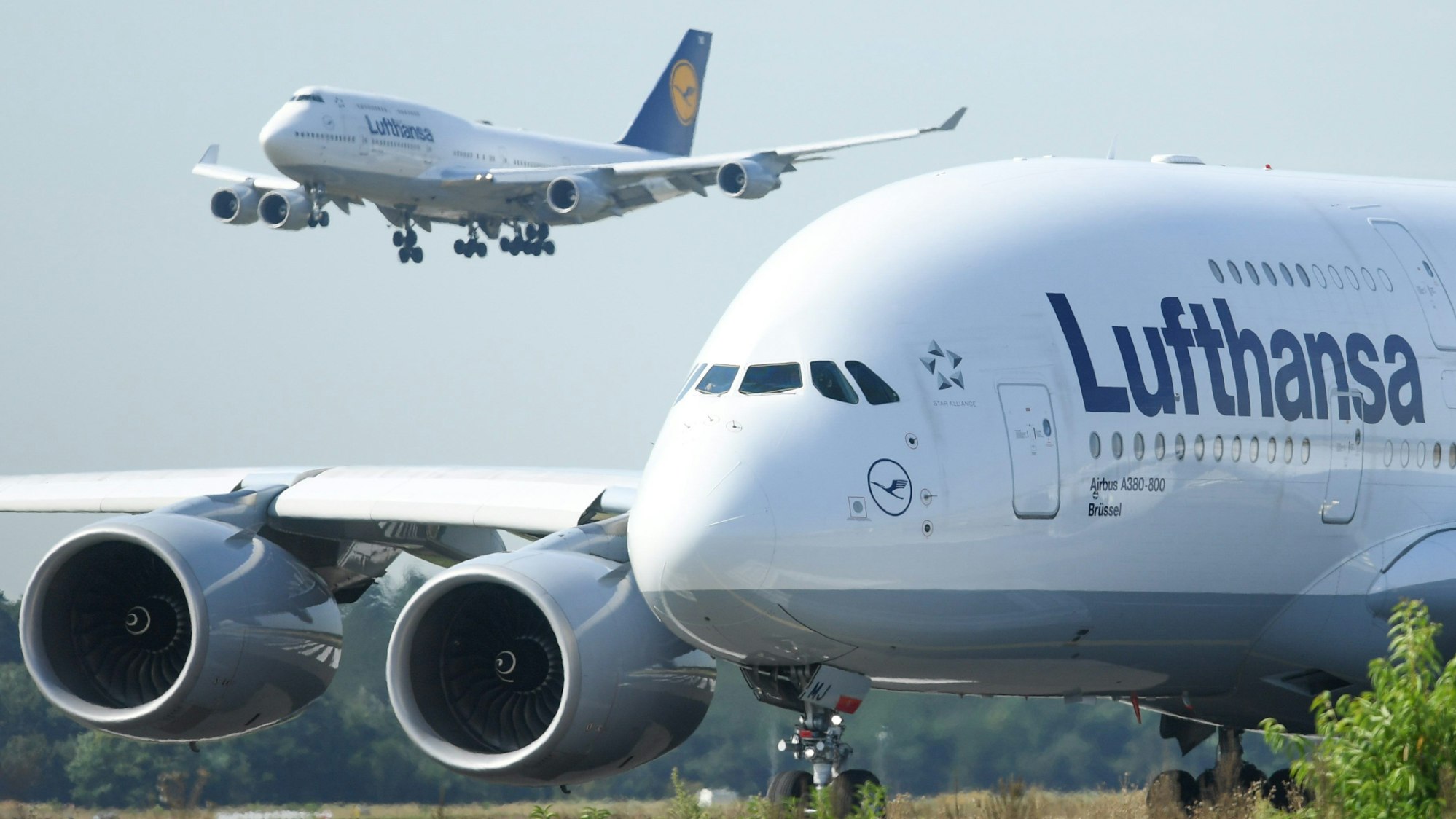 Eine Boeing 747-400 der Lufthansa landet am Flughafen von Frankfurt am Main hinter einem startbereiten Airbus A380-800.