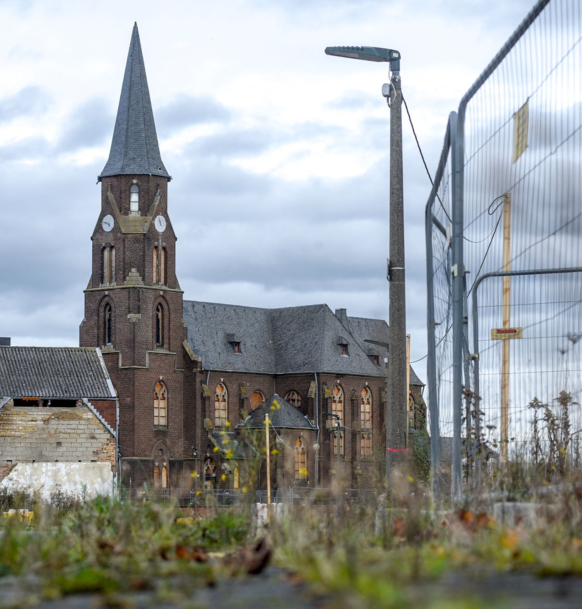 Vor der ehemaligen Kirche steht ein Zaun.