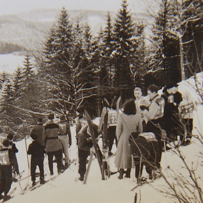 Skifahrer am Hang mit Nummernleibchen.