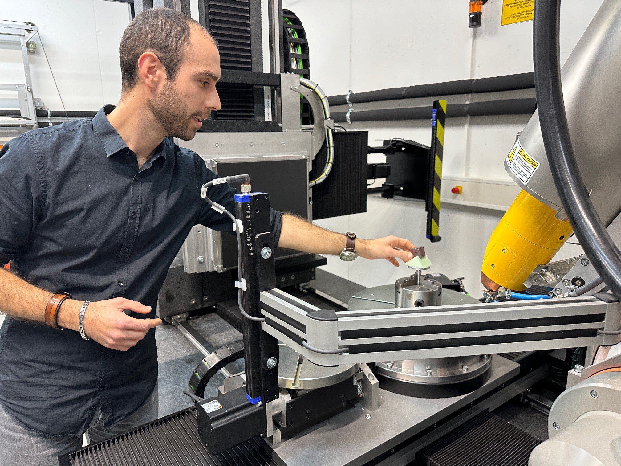 29.11.2023, Rheinland-Pfalz, Mainz: Paläontologe Ivan Calandra vom         Leibniz-Zentrum für Archäologie (Leiza) platziert eine Gesteinsprobe zur Untersuchung mit dem 3D-Computertomographen. Ein internationales Forscherteam untersucht mit Hilfe eines in Europa einzigartigen 3D-Computertomographen in Mainz 1,6 Millionen Jahre alte Schlagwerkzeuge. Foto: Ira Schaible/dpa +++ dpa-Bildfunk +++