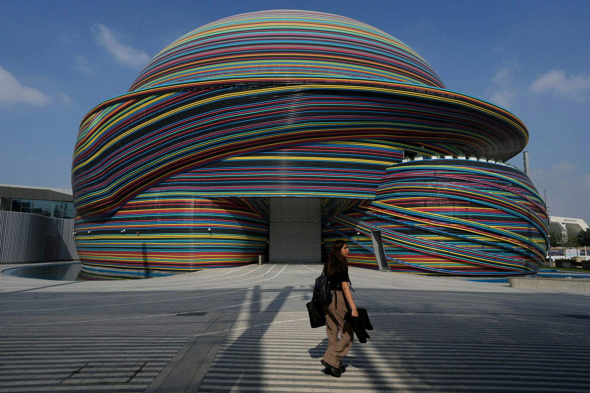 29.11.2023, Vereinigte Arabische Emirate, Dubai: Eine Frau geht vor dem Beginn der Weltklimakonferenz COP28 über das Gelände des UN-Klimagipfels