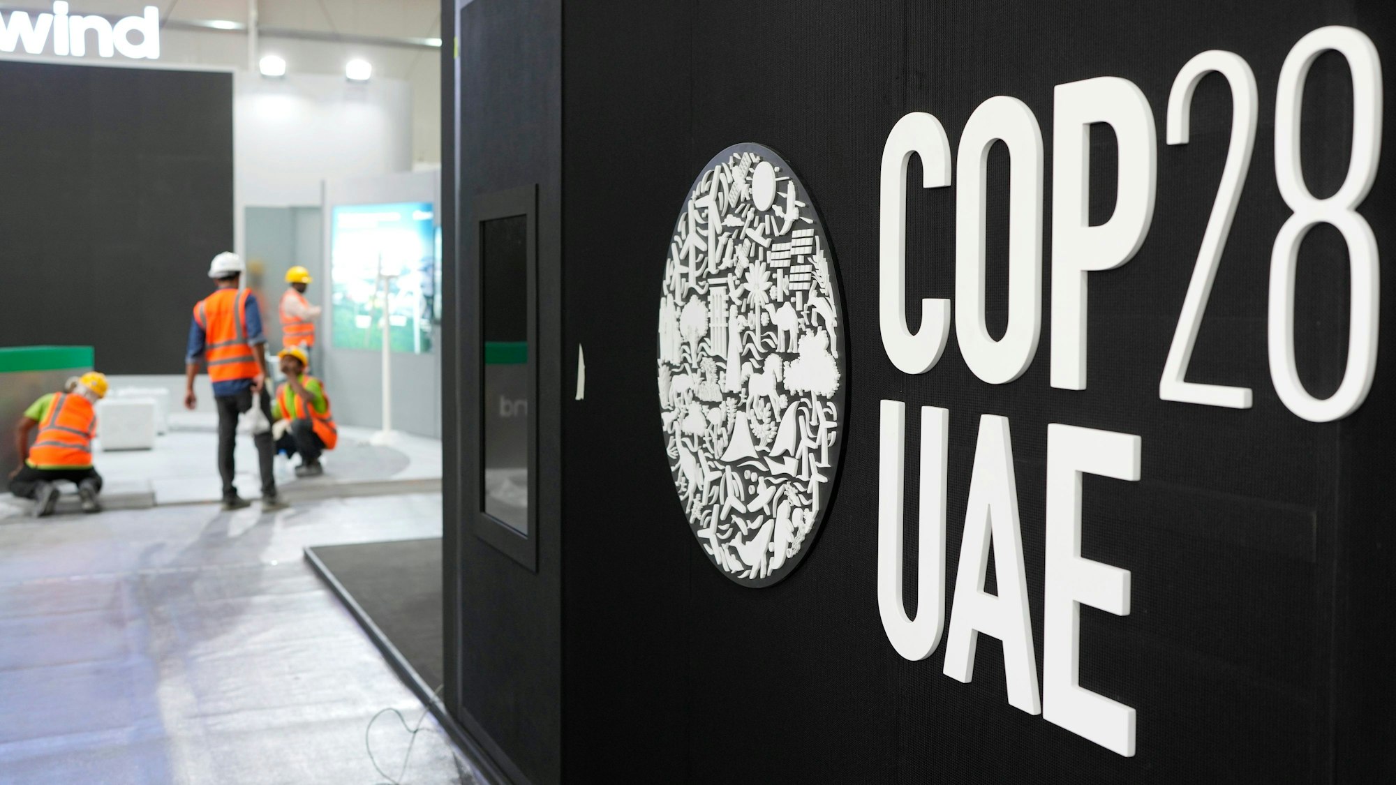 Dubai: Arbeiter bauen vor dem Beginn der Weltklimakonferenz COP28 in der Nähe eines Logos des UN-Klimagipfels Stände auf.