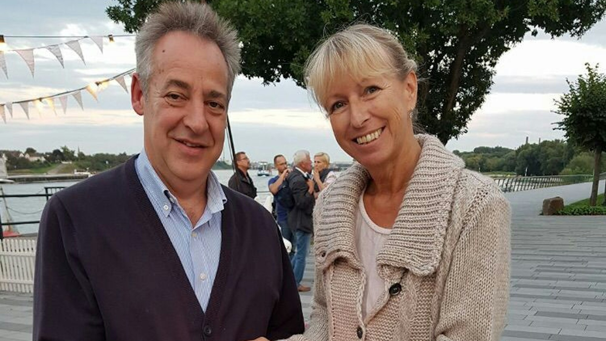 Ein Mann und eine Frau legen die Hände schützend um ein Licht.