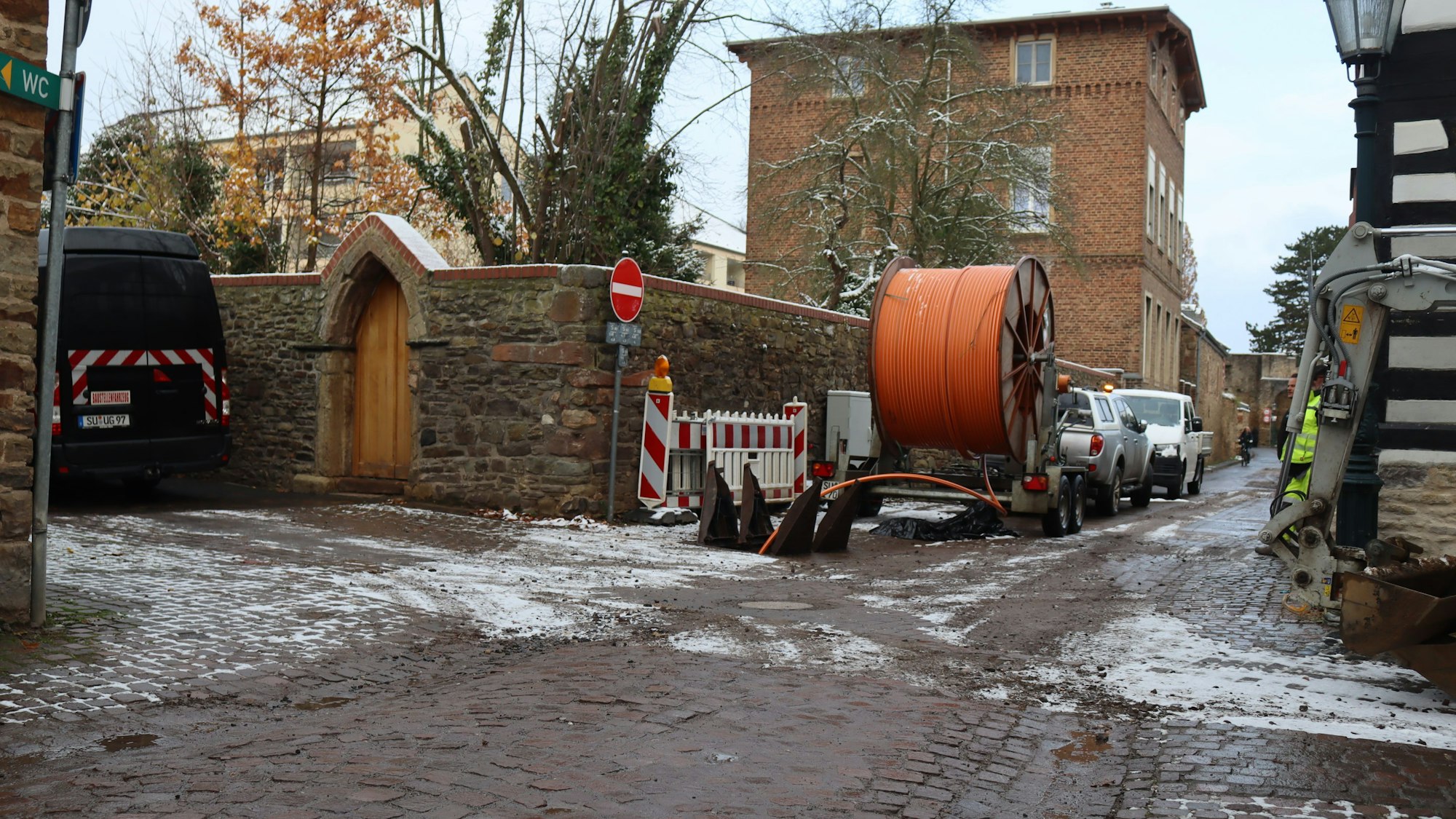 Auf der Alten Gasse in Bad Münstereifel wird zwischen Kapuzinergasse und Wallgasse derzeit gearbeitet. Ein Anhänger mit Kabeln steht an der Seite.