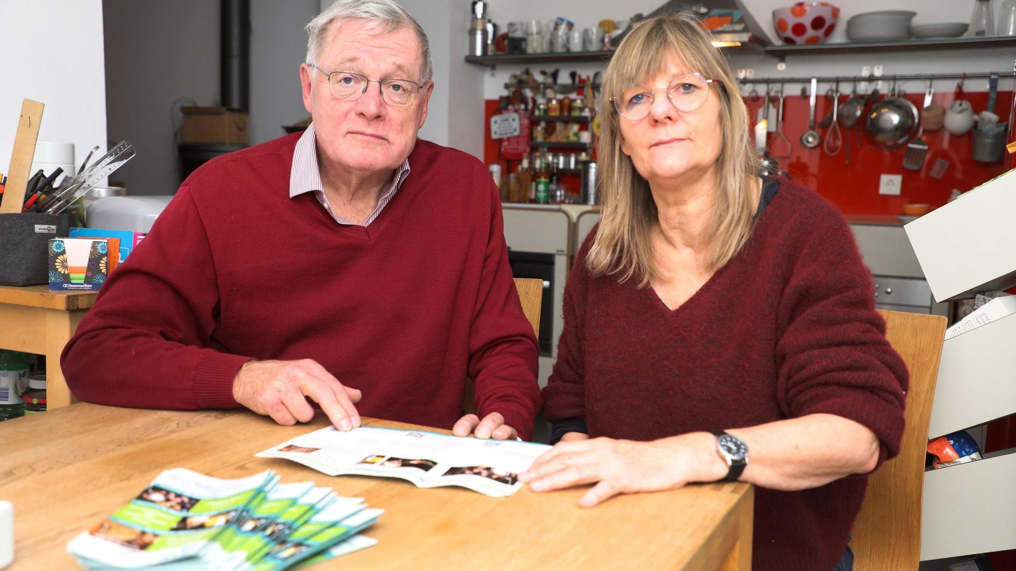 Der Vorsitzende des Kulturforums Overath, Jürgen Wesche, und Vize-Vorsitzende Margret Altemeier sitzen mit sorgenvoller Miene an einem Tisch und halten das Programm des Kulturforums in den Händen.
