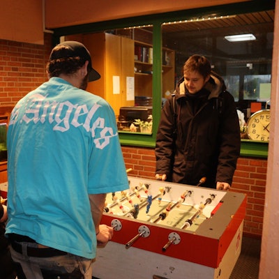 Sozialarbeiter Gereon Hostat (r.) spielt mit zwei betreuten Jugendlichen am Tischkicker.