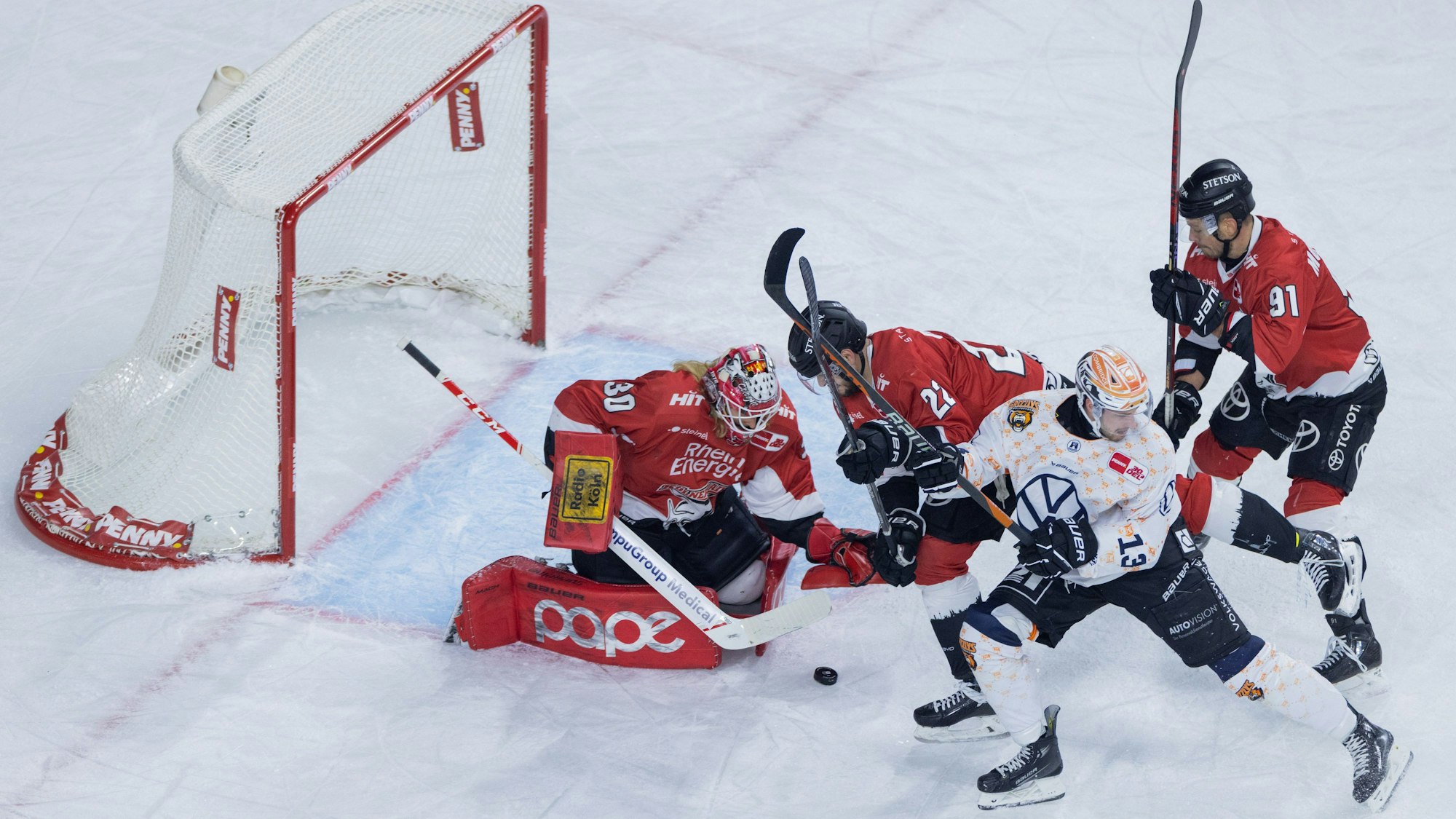 Eishockey: DEL, Kölner Haie - Grizzlys Wolfsburg, Hauptrunde, 22. Spieltag, Lanxess Arena. Kölns Mirko Pantkowski (l-r), Maximilian Gloetzl und Moritz Müller und Wolfsburgs Lucas Dumont versuchen an den Puck zu kommen. Foto: Rolf Vennenbernd/dpa +++ dpa-Bildfunk +++