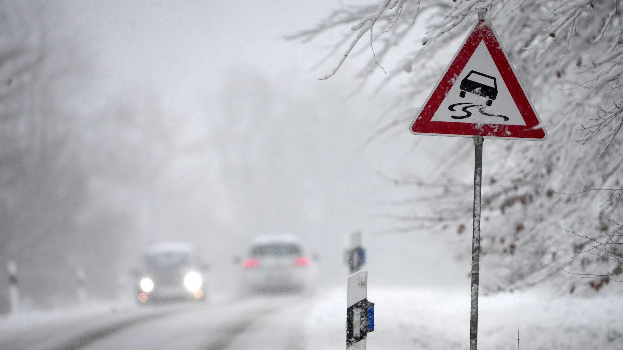 Starker Schneefall hat in Deutschland vor allem in höheren Lagen Chaos auf den Straßen verursacht. Mehrere Autos sind im Schnee auf einer Landstraße eingeschlossen.