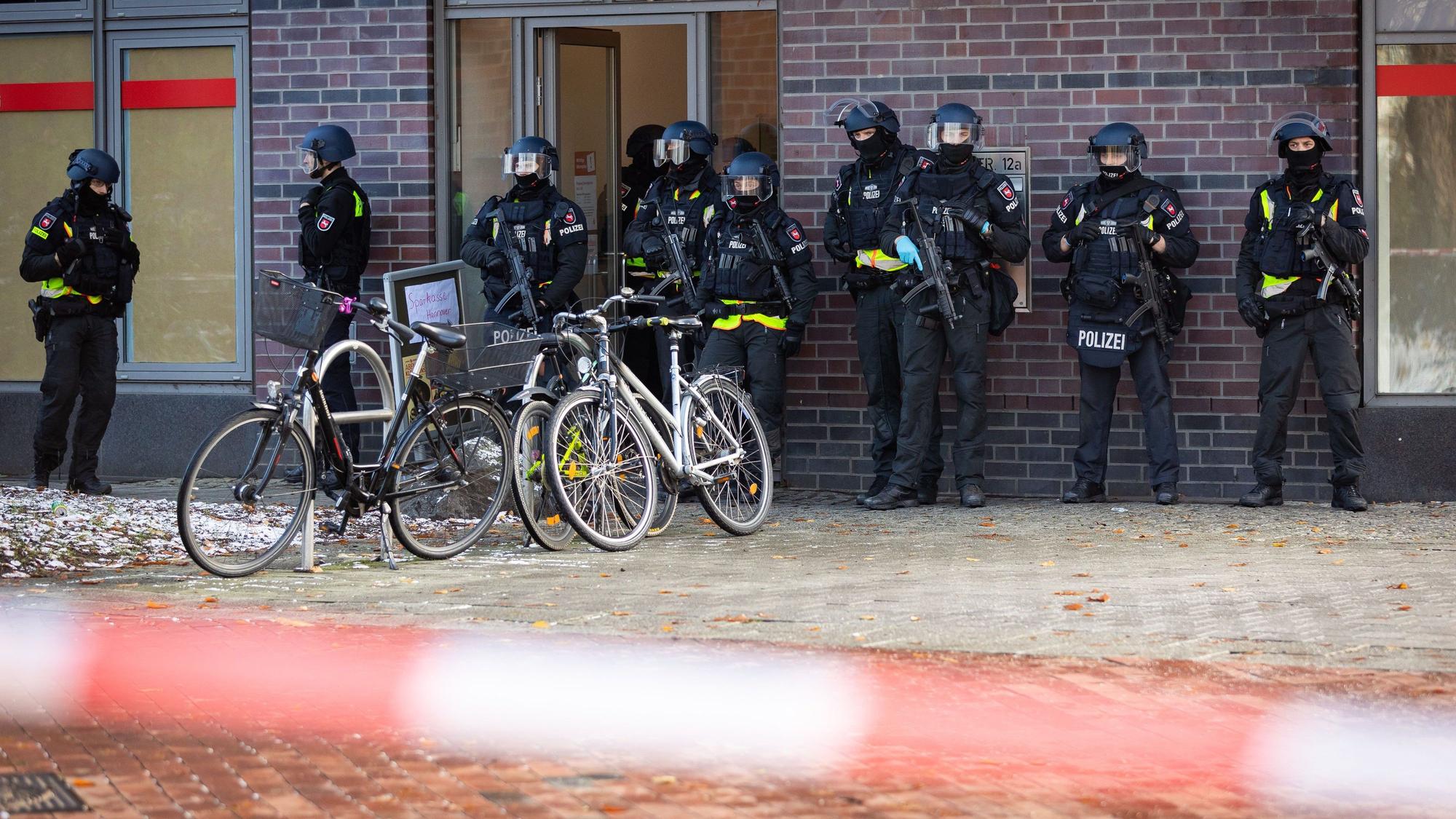 30.11.2023, Niedersachsen, Lehrte: Einsatzkräfte der Polizei sind in einem abgesperrten Bereich vor einem Jobcenter im Einsatz.
