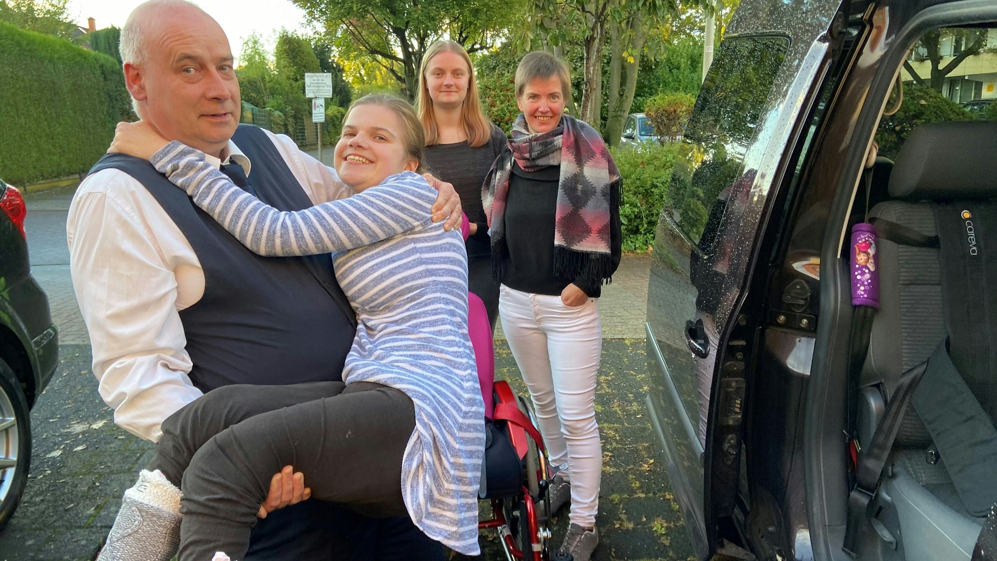 Auf dem Bild ist zu sehen, wie Sascha Sturm seine Tochter ins Auto hebt.