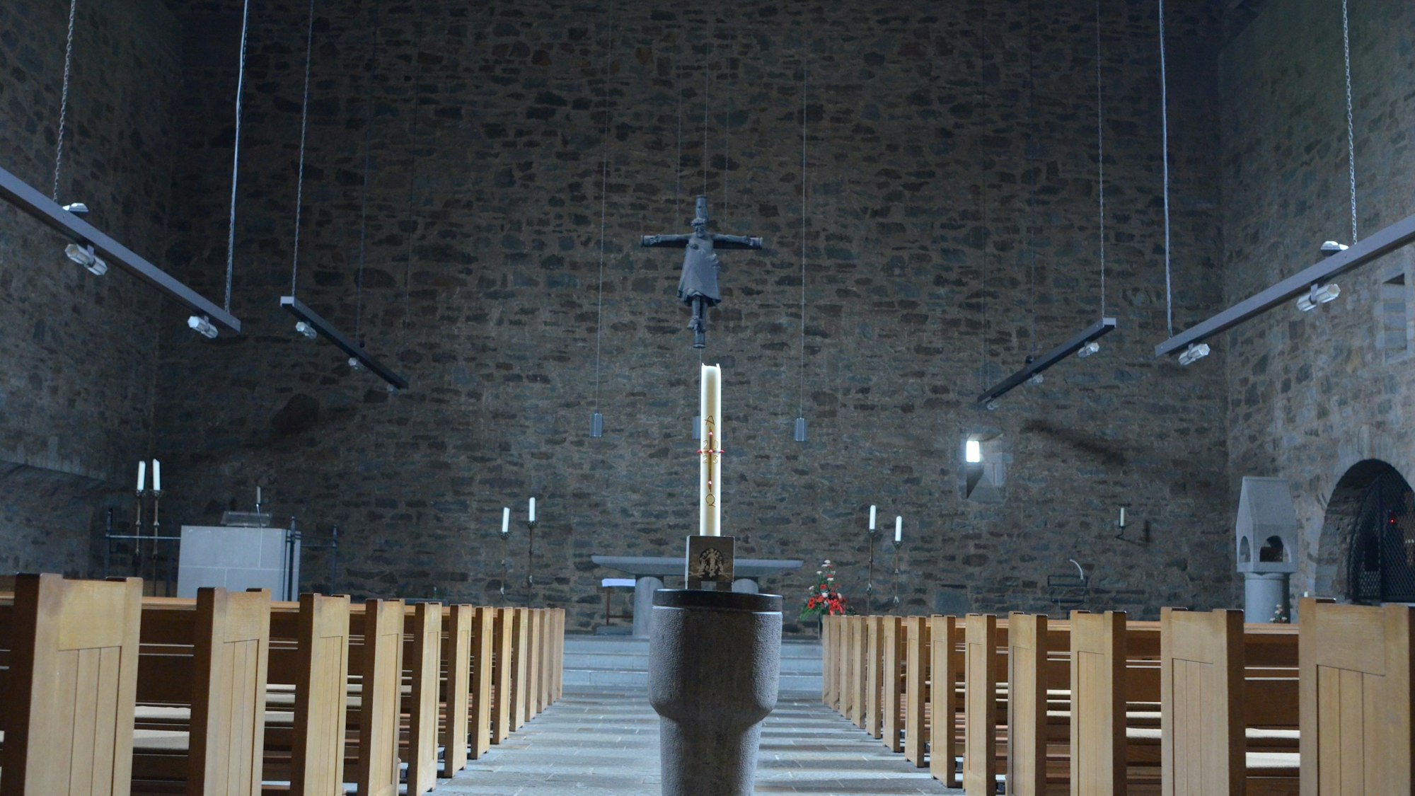 Ein Blick in die Euskirchener Kirche St. Matthias, im Vordergrund der Taufstein, hinten der Altarraum mit Kruzifix.