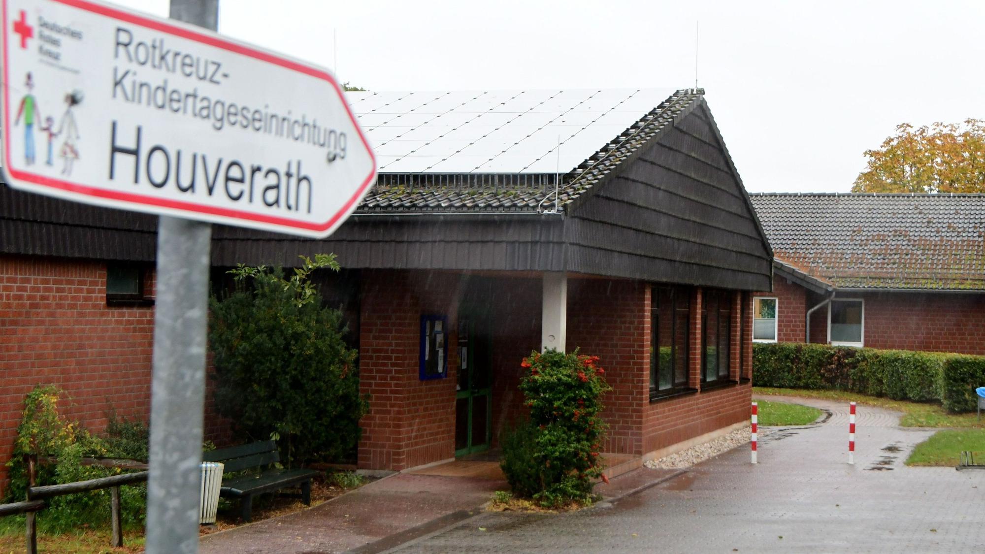 Da Foto zeigt die Kindertagesstätte Houverath. Im Vordergrund ein Wegweiser..