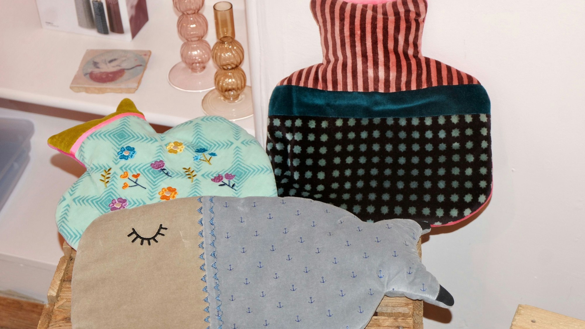 Wärmflaschen liegen auf einem Holzhocker.