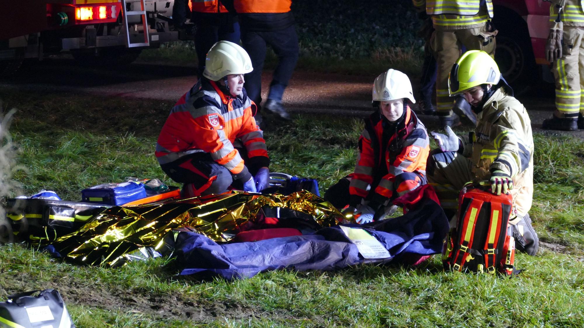 Rettungskräfte knien vor zwei Übungspuppen.