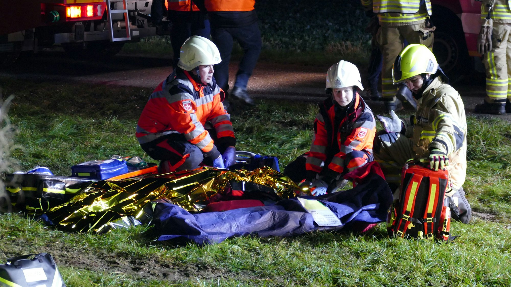 Rettungskräfte knien vor zwei Übungspuppen.