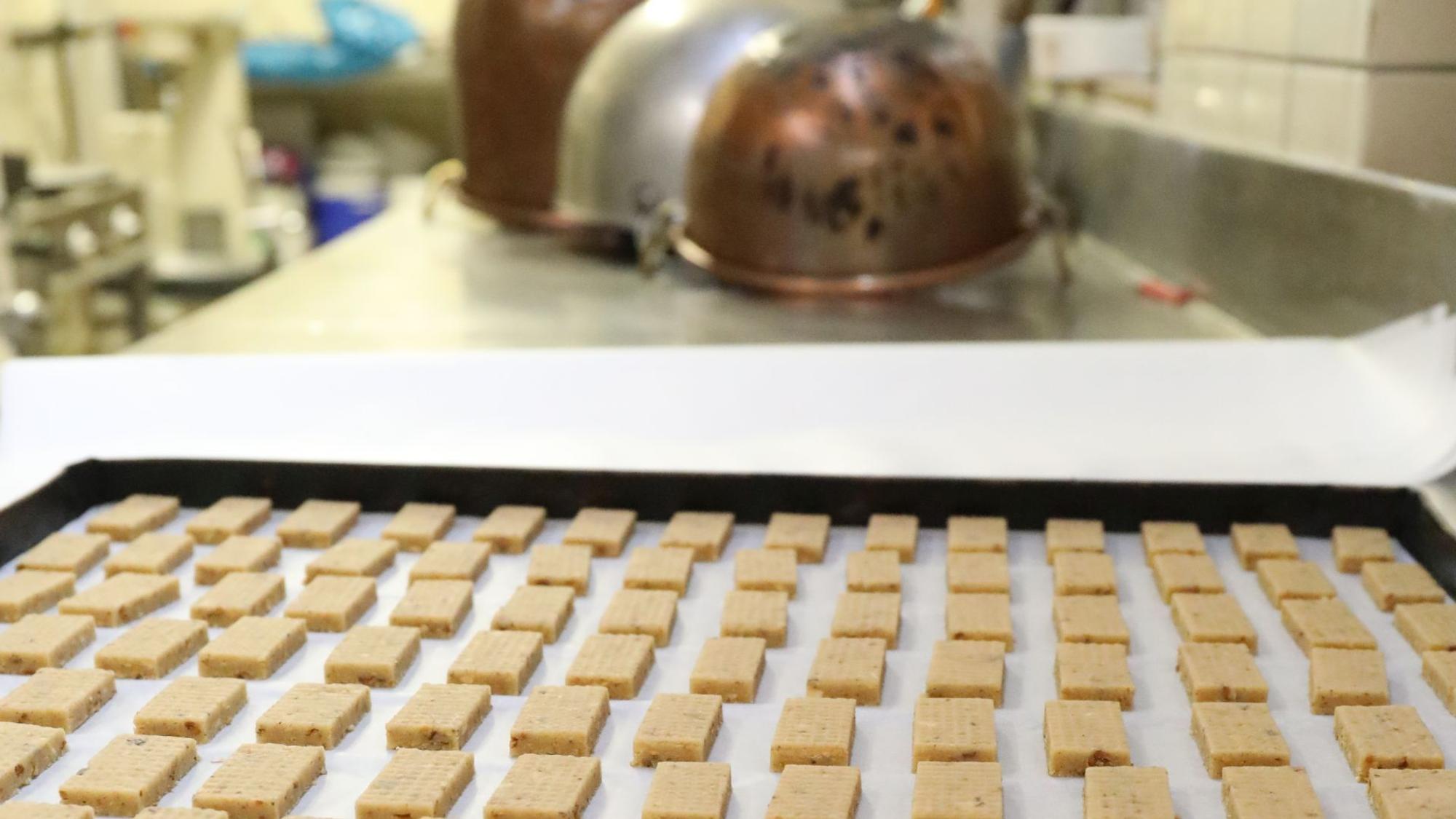 Vorbereitete Plätzchen liegen in der Backstube auf einem Kuchenblech.