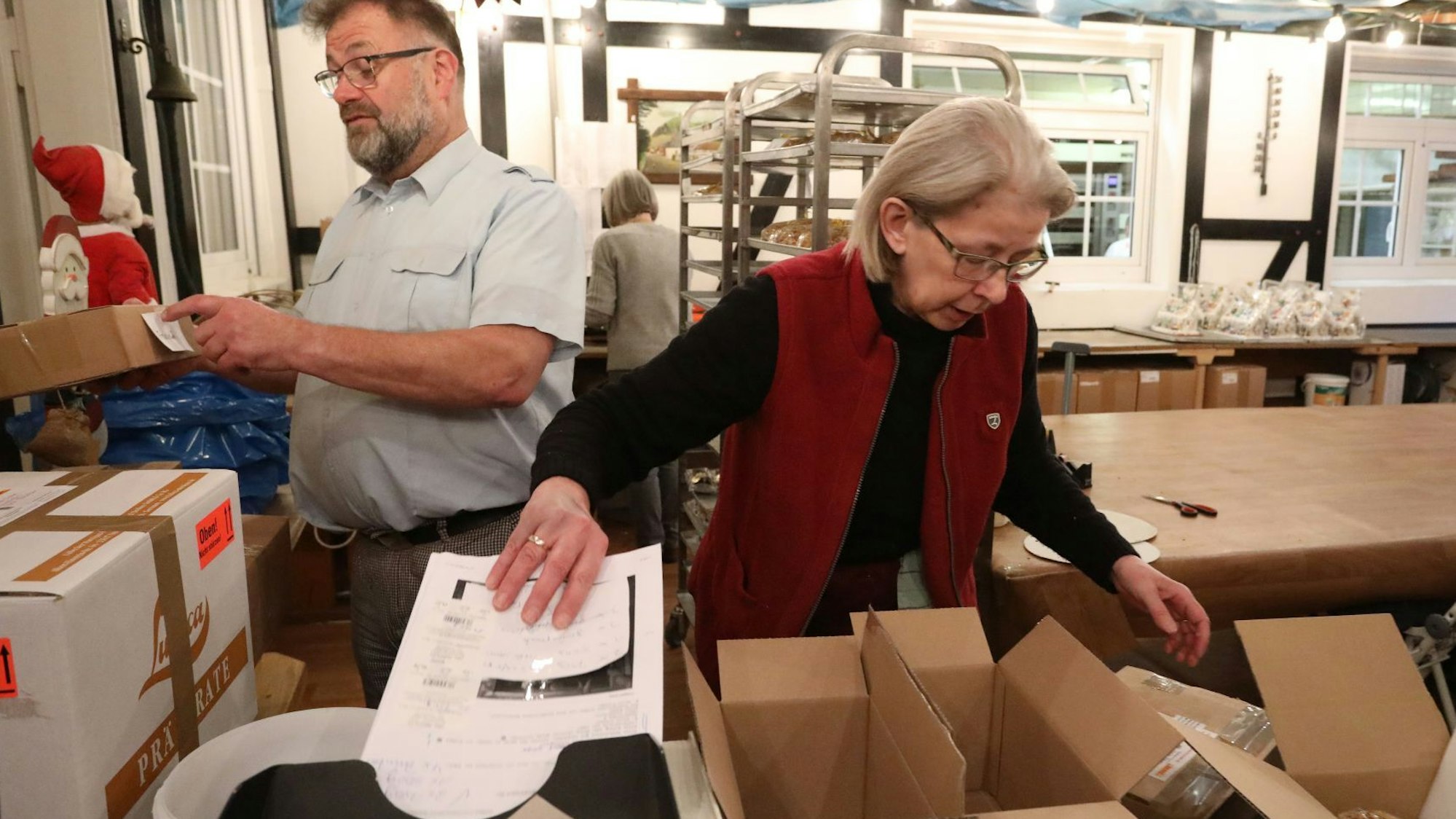 Ein Mann und eine Frau verpacken die Stollen in Kartons, um sie in alle Welt zu verschicken.