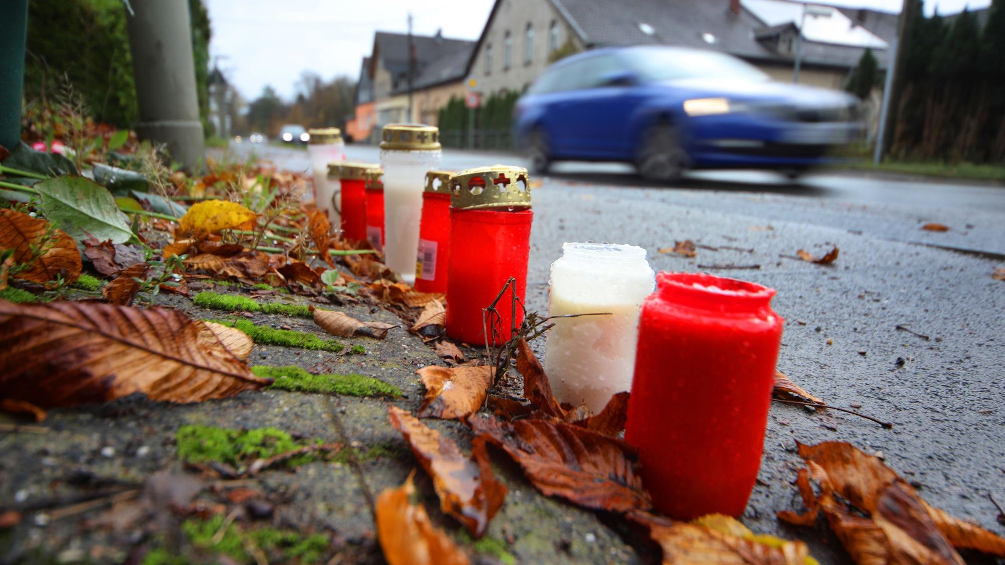 Am Straßenrand stehen Grabkerzen.