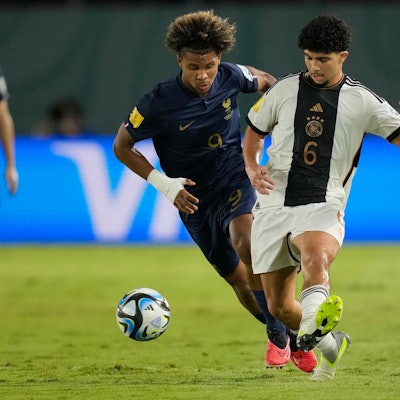 Zwei Fußballspieler kämpfen um den Ball.