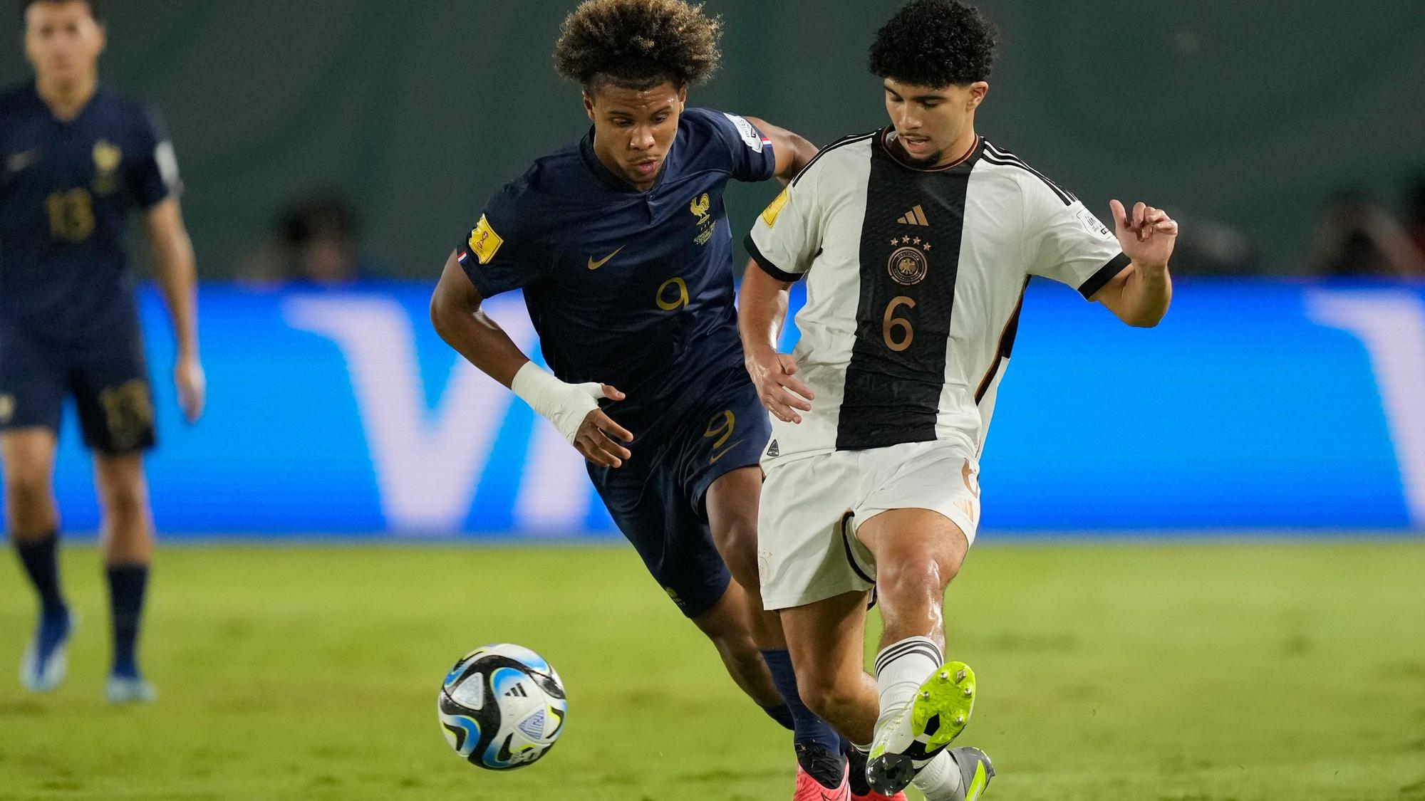 Zwei Fußballspieler kämpfen um den Ball.