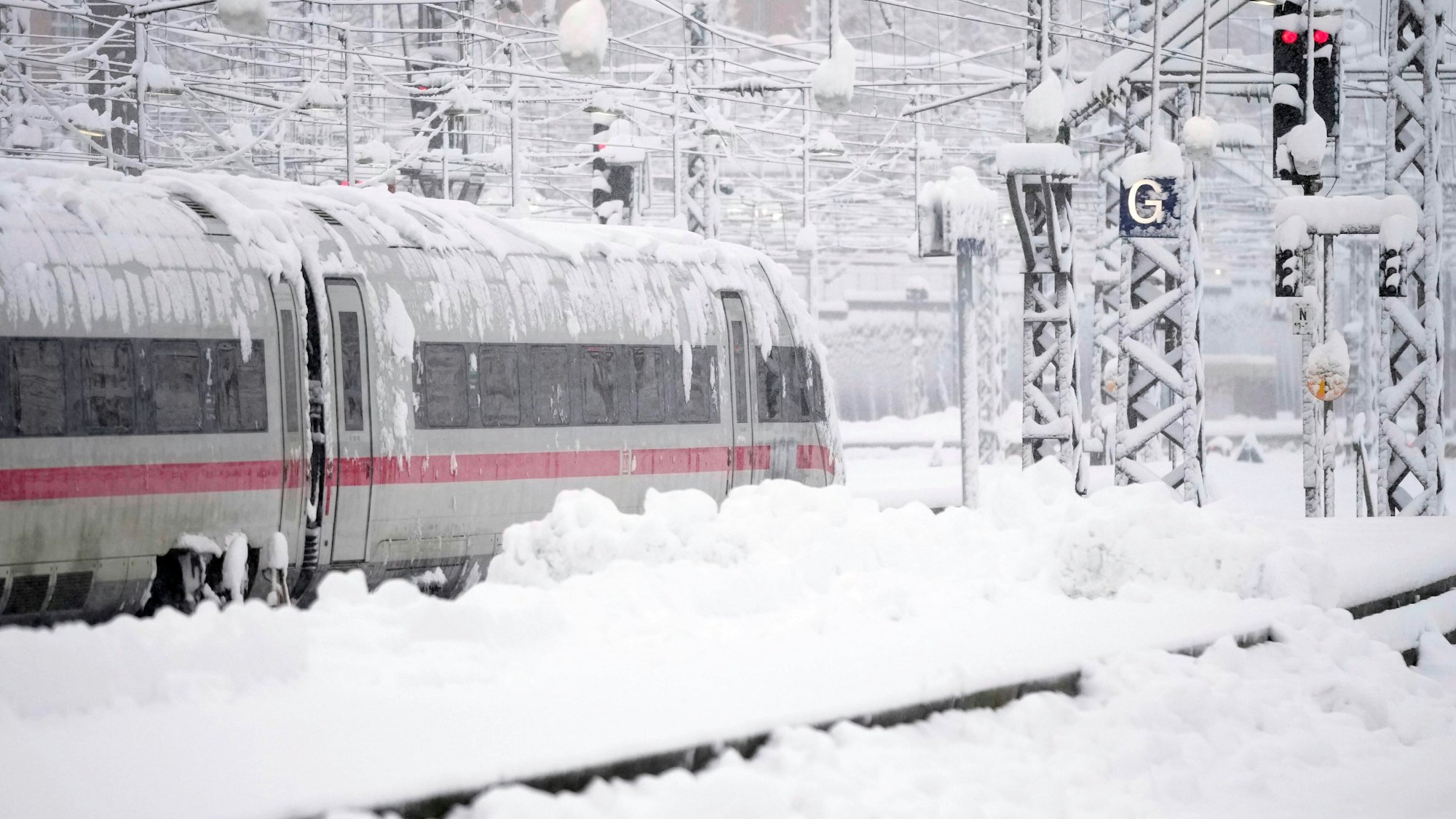 02.12.2023, Bayern, München: Ein ICE steht nach starkem Schneefall am Hauptbahnhof. Schnee und Eis haben im Süden Bayerns auf den Straßen und bei der Bahn für Chaos gesorgt. Foto: Matthias Schrader/AP/dpa +++ dpa-Bildfunk +++