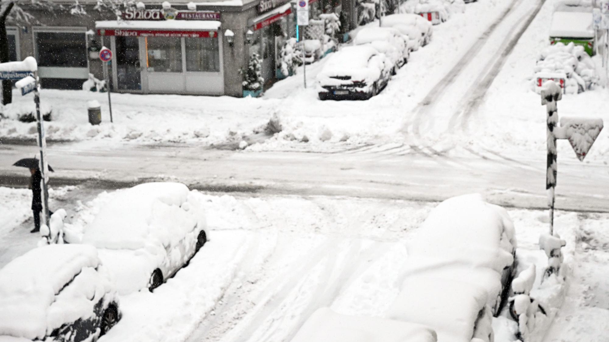02.12.2023, Bayern, München: Hohe Schneemassen liegen auf Autos und einer Kreuzung in der Landeshauptstadt. Schnee und Eis haben im Süden Bayerns auf den Straßen und bei der Bahn für Chaos gesorgt. Foto: Felix Hörhager/dpa +++ dpa-Bildfunk +++