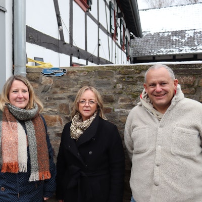 Peter Schellenberger, Stefanie Liebing, Sabine Preiser-Marian und Peter Greven stehen vor einem Haus. Im Hintergrund sieht man die Flutmarke an einer Mauer.