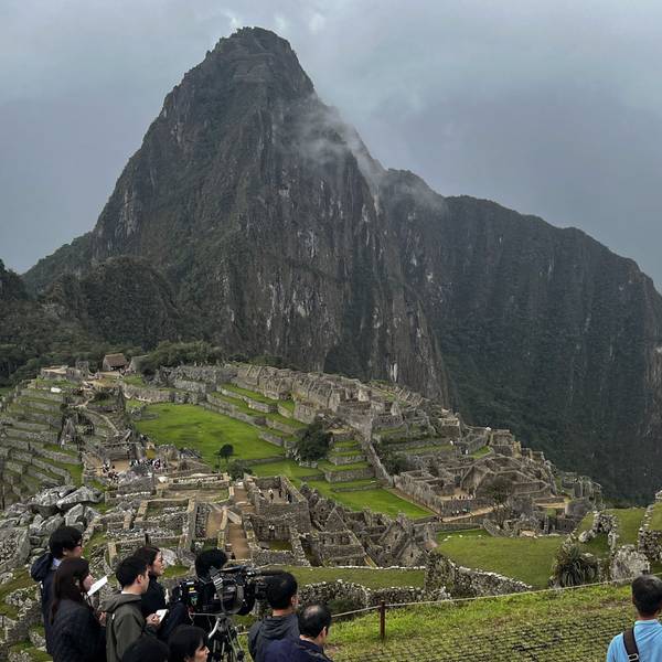 Eine Gruppe von Touristen steht am Rande des Machu Picchu in Peru.