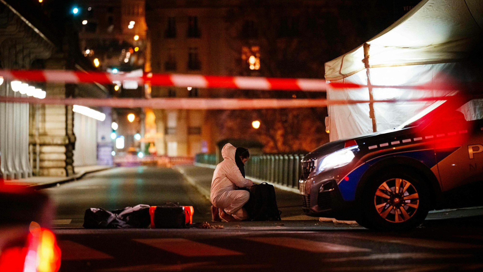 Ein Beamter der Kriminalpolizei arbeitet am Tatort in Paris. Ein mutmaßlicher Islamist hat unweit des Eiffelturms am Samstagabend einen deutschen Touristen mit einem Messer getötet. Zwei weitere Menschen seien verletzt worden, einer davon mit einem Hammer.