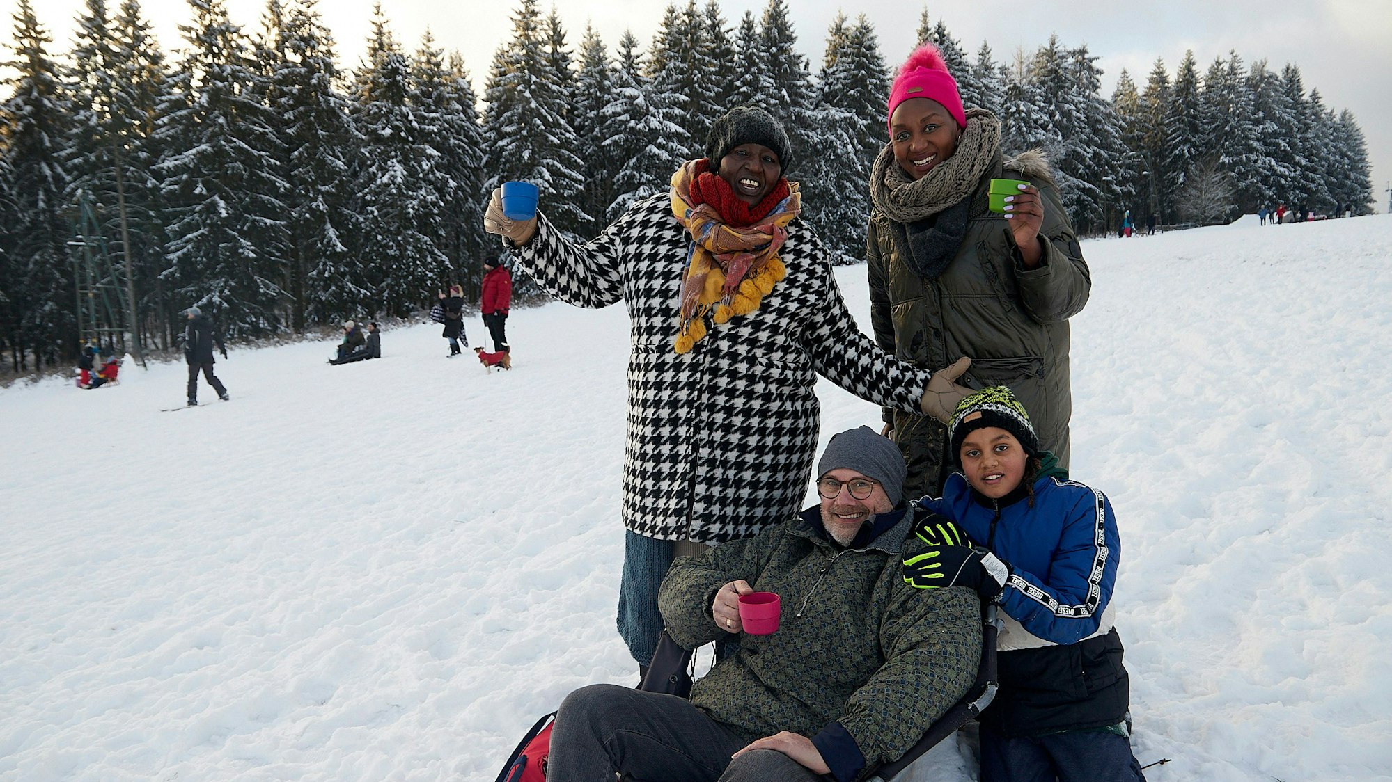 Die Familie genießt die Idylle auf dem Rodelhang.