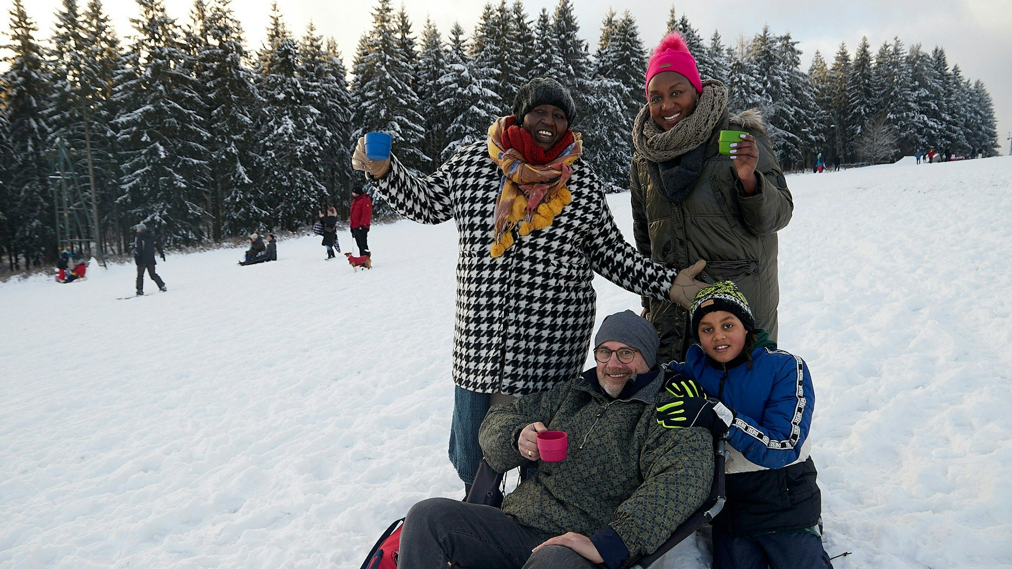 Die Familie genießt die Idylle auf dem Rodelhang.