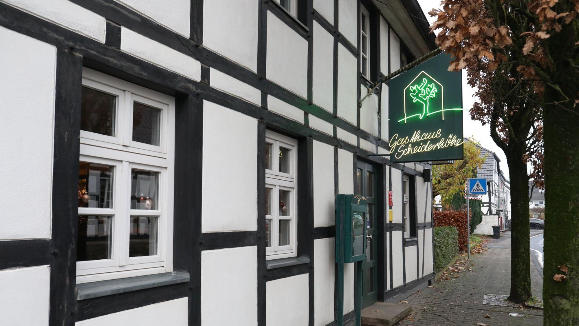 Blick auf das Gasthaus Scheiderhöhe im Lohmar mit historischem Fachwerk und grünem Werbeschild.